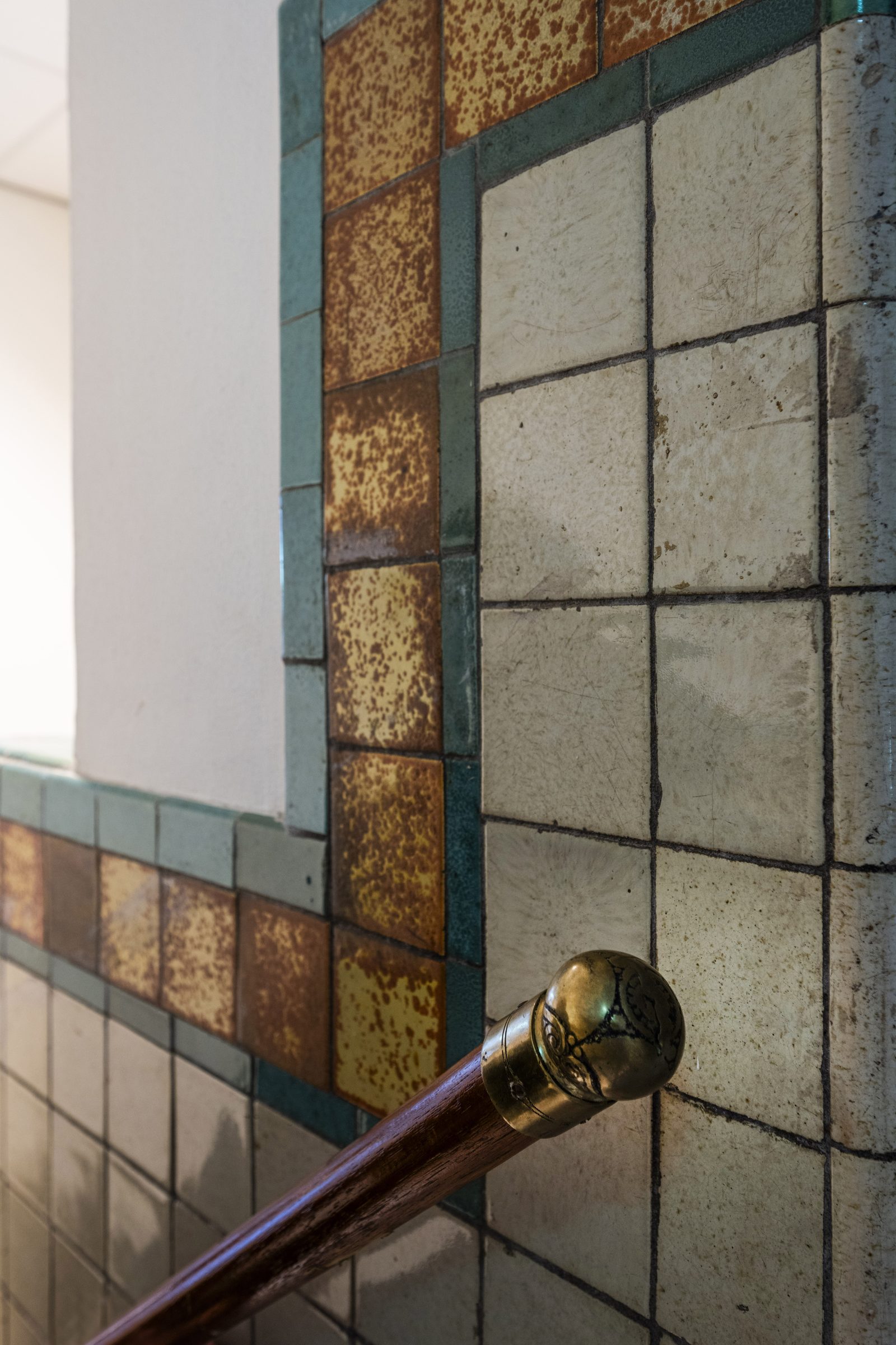 Restored heritage tilework and brass detailing inside The Foundry, Amsterdam